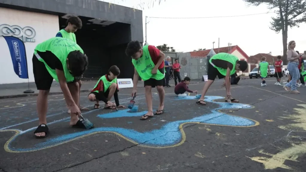 Crianças pintam rua em Campo Grande para resgatar tradição de Copa