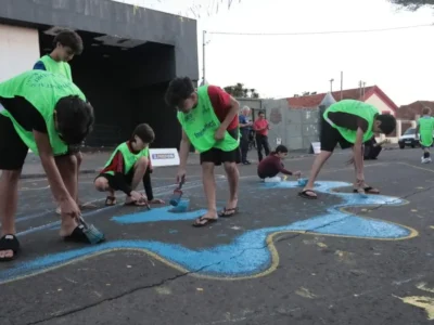 Crianças pintam rua em Campo Grande para resgatar tradição de Copa